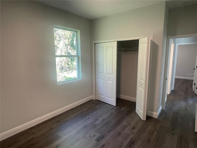 unfurnished bedroom featuring dark hardwood / wood-style flooring and a closet