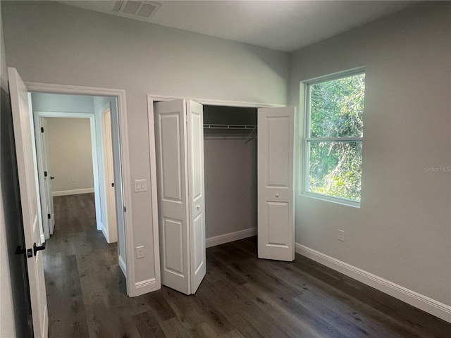 unfurnished bedroom featuring dark wood-type flooring and a closet