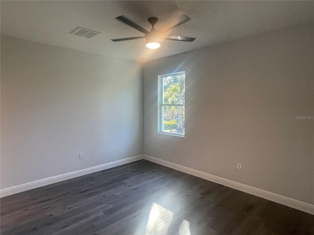 spare room featuring dark wood-type flooring and ceiling fan