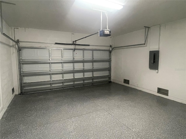 garage with a garage door opener and electric panel