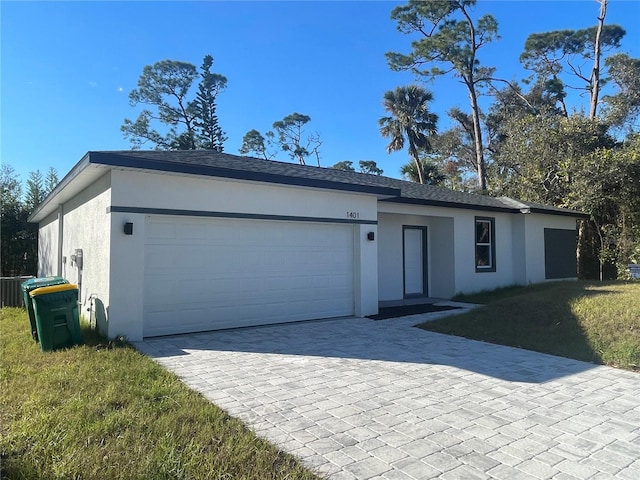 ranch-style home with a garage and a front lawn