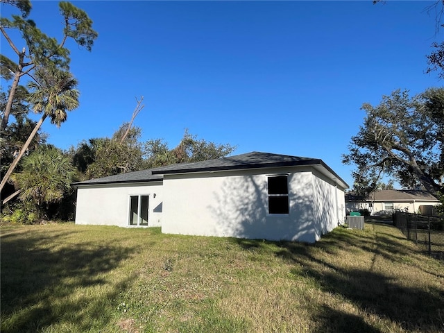 rear view of property featuring a yard and central AC unit