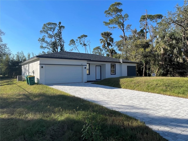 single story home featuring central AC, a garage, and a front yard