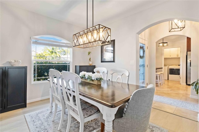 dining space featuring washing machine and dryer, a healthy amount of sunlight, and light hardwood / wood-style floors