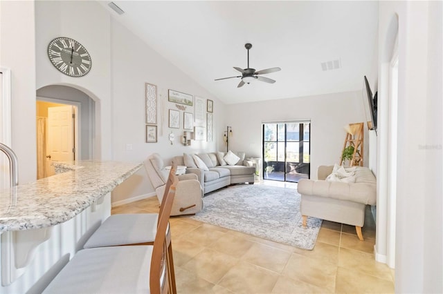 living room with lofted ceiling, ceiling fan, and light tile patterned flooring