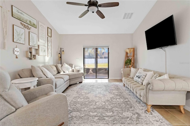 living room featuring ceiling fan, lofted ceiling, and light tile patterned floors