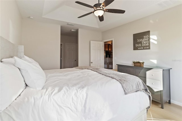 bedroom featuring ceiling fan and a tray ceiling