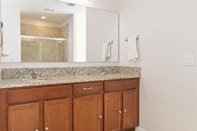 bathroom with vanity and a shower with shower door