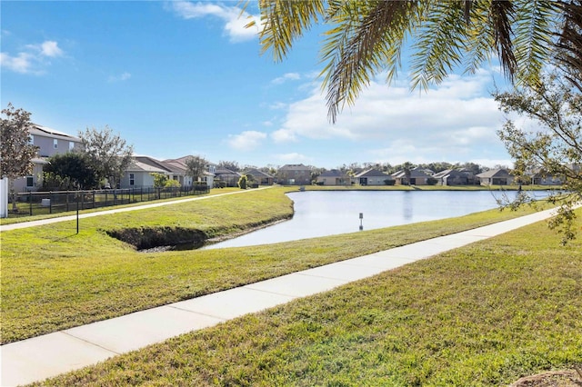 view of home's community with a water view and a yard