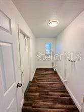 hallway with dark hardwood / wood-style flooring