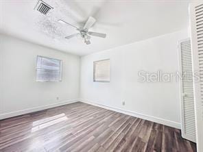 unfurnished bedroom featuring ceiling fan and dark hardwood / wood-style flooring