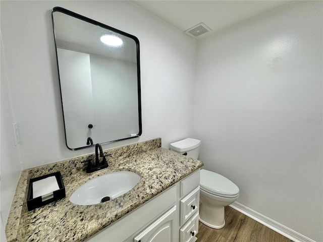 bathroom featuring hardwood / wood-style flooring, vanity, and toilet