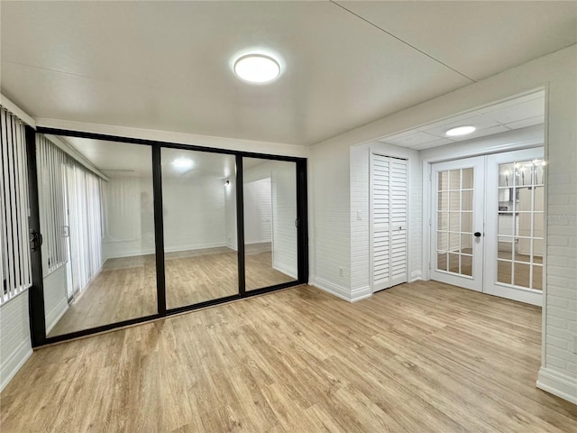 unfurnished bedroom with light hardwood / wood-style floors and french doors