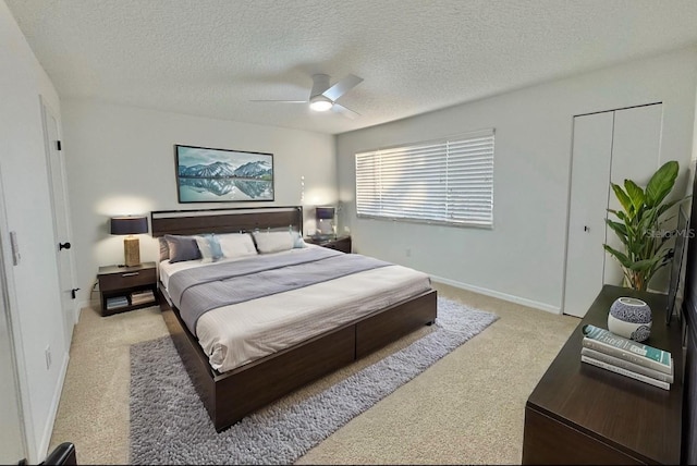 bedroom featuring ceiling fan, light carpet, and a textured ceiling