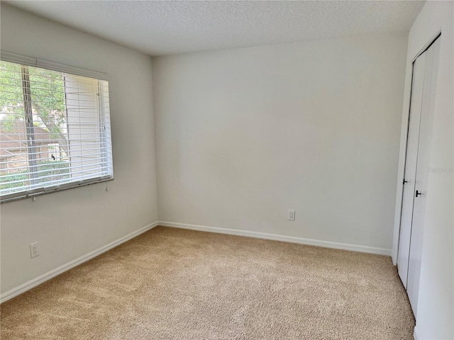 carpeted spare room with a textured ceiling