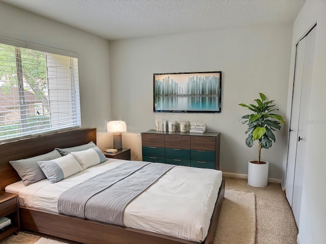 bedroom featuring light carpet and a textured ceiling