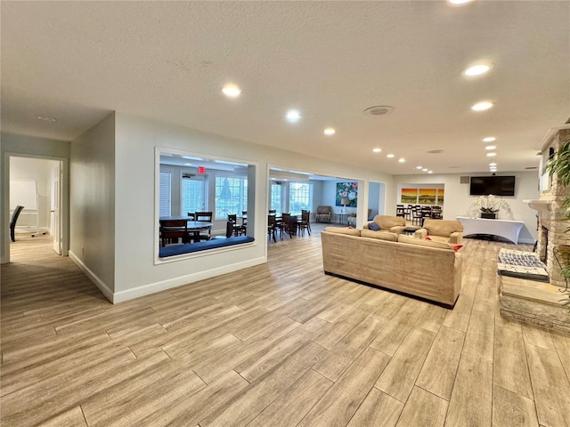 living room featuring a textured ceiling and light wood-type flooring