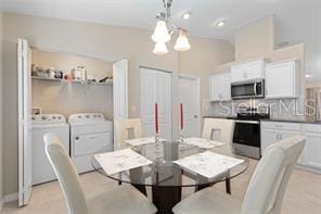 dining area featuring washer and dryer and a chandelier