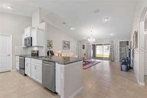 kitchen featuring light tile patterned floors, decorative light fixtures, white cabinets, and appliances with stainless steel finishes