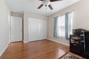 bedroom featuring wood-type flooring, a closet, and ceiling fan