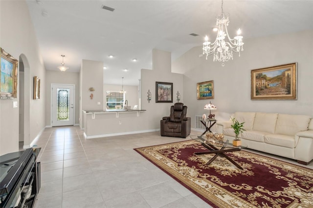 living room featuring visible vents, arched walkways, baseboards, lofted ceiling, and light tile patterned flooring