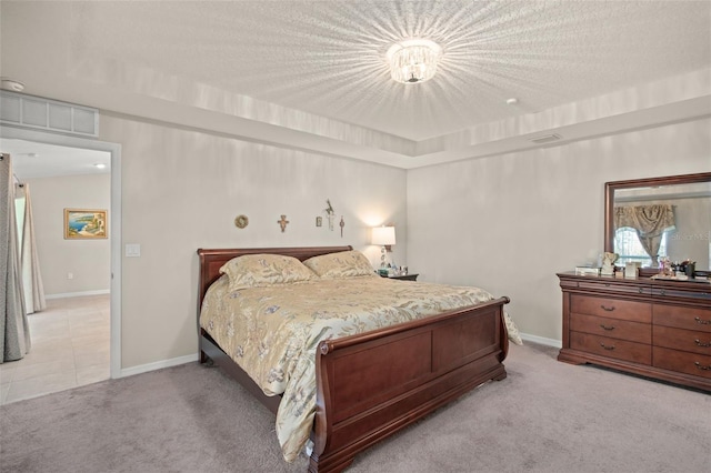 bedroom with carpet, a textured ceiling, visible vents, and baseboards