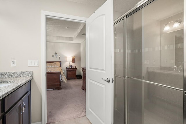 bathroom featuring a textured ceiling, a stall shower, connected bathroom, and vanity