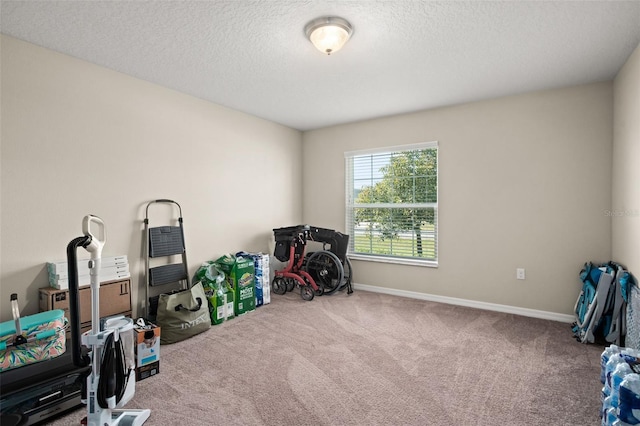 rec room featuring carpet floors, baseboards, and a textured ceiling