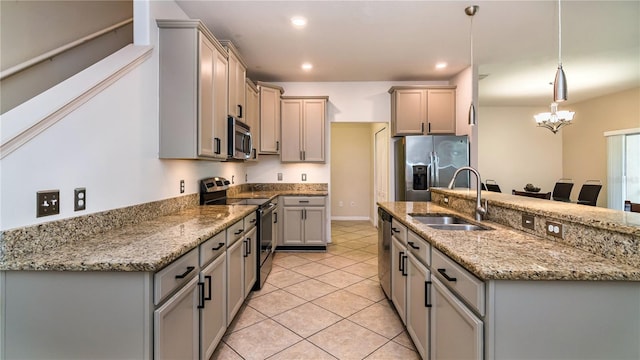 kitchen featuring light tile patterned flooring, decorative light fixtures, sink, stainless steel appliances, and light stone countertops