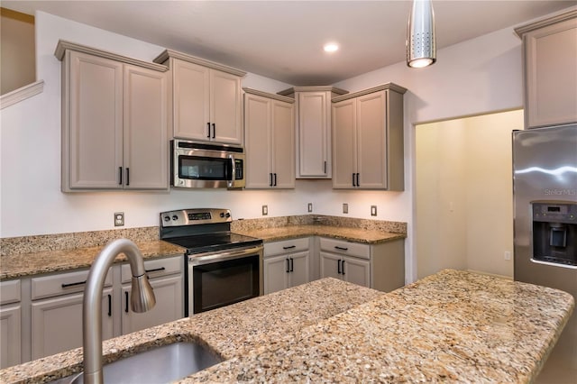 kitchen featuring sink, gray cabinetry, hanging light fixtures, stainless steel appliances, and light stone countertops