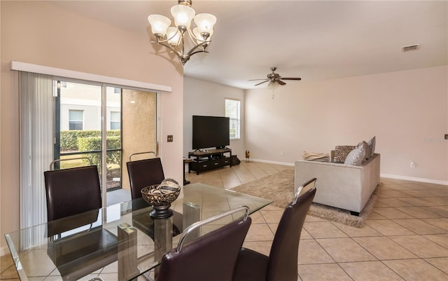 tiled dining space with ceiling fan with notable chandelier