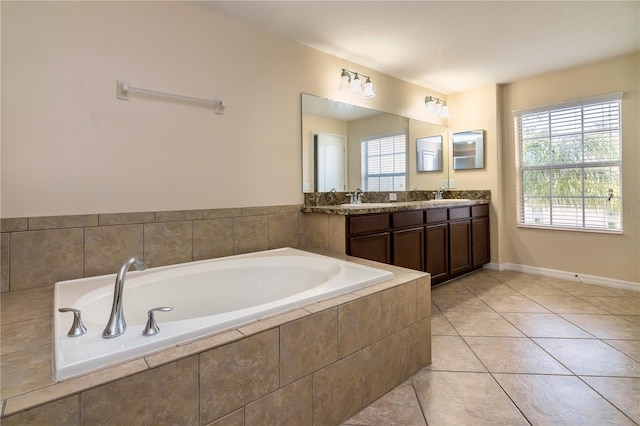 bathroom featuring a relaxing tiled tub, tile patterned floors, and vanity