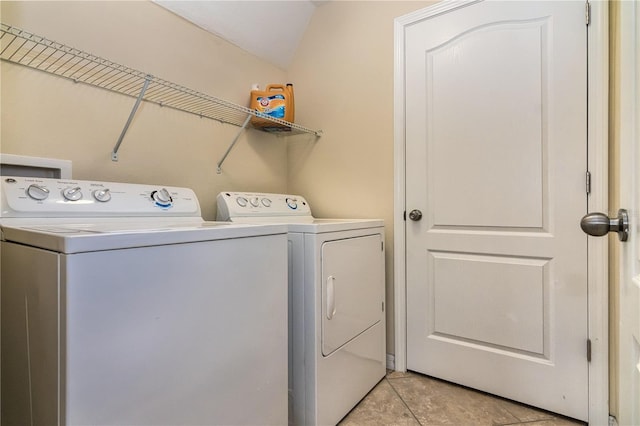 clothes washing area with washing machine and clothes dryer and light tile patterned floors