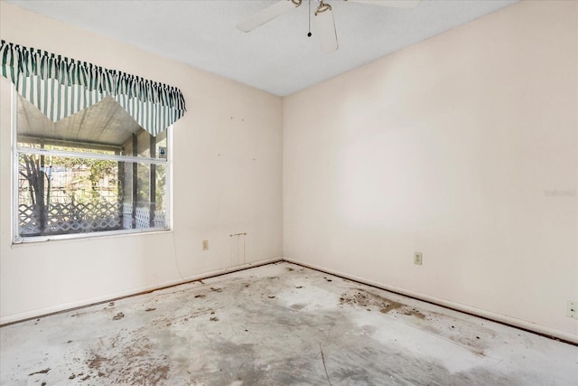 spare room featuring concrete floors and ceiling fan