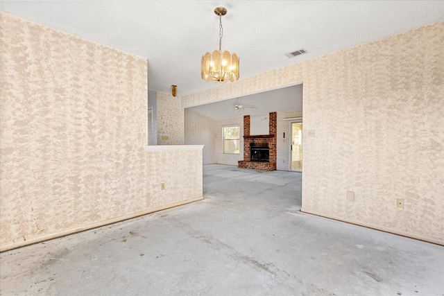 interior space featuring a fireplace, ceiling fan with notable chandelier, and concrete floors