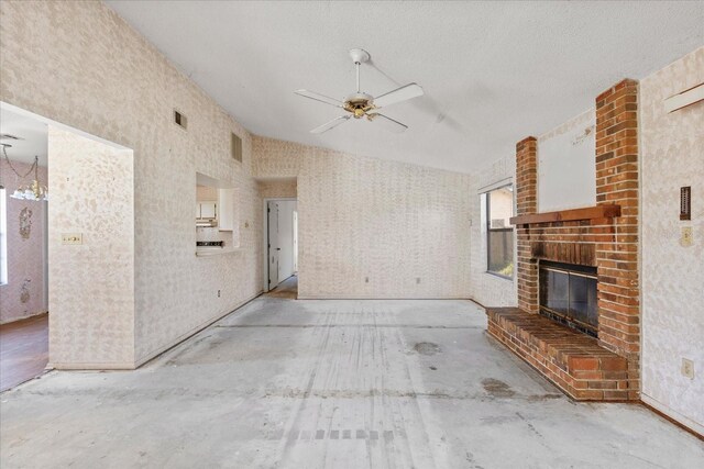 unfurnished living room featuring ceiling fan, a fireplace, a textured ceiling, and concrete floors