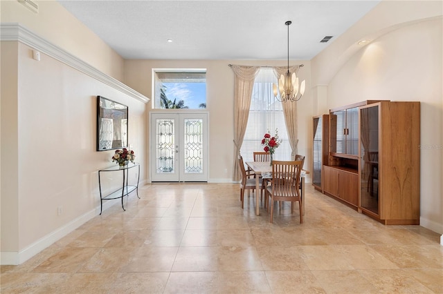 tiled dining space featuring french doors and a chandelier