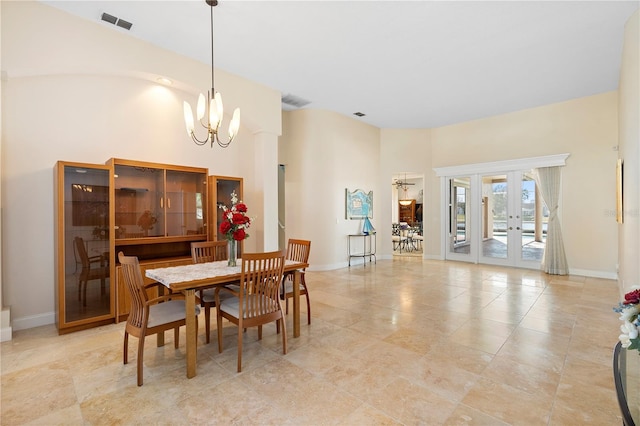 dining space with french doors, a chandelier, and a high ceiling