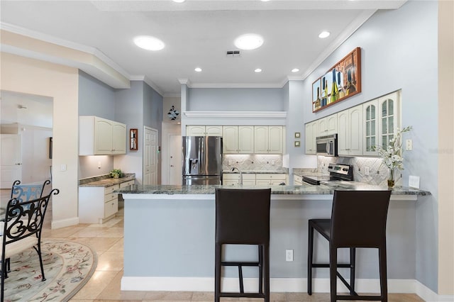 kitchen with stainless steel appliances, ornamental molding, a kitchen breakfast bar, and kitchen peninsula