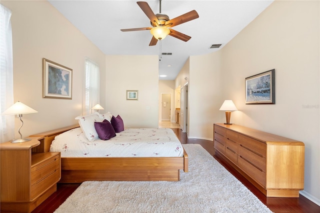 bedroom featuring dark hardwood / wood-style flooring, connected bathroom, and ceiling fan