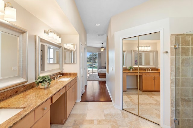 bathroom featuring walk in shower, ceiling fan, and vanity