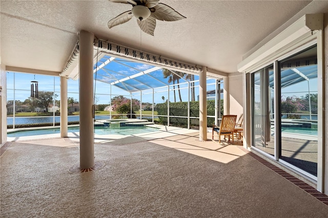 view of pool featuring an in ground hot tub, a patio, ceiling fan, and glass enclosure