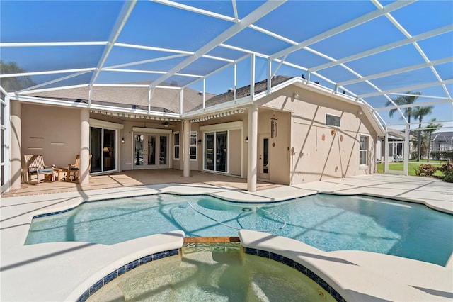 view of pool featuring a patio, glass enclosure, and an in ground hot tub