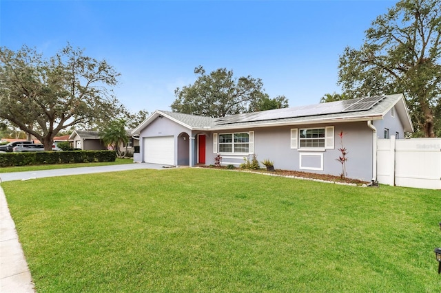 ranch-style home featuring a garage, a front lawn, and solar panels