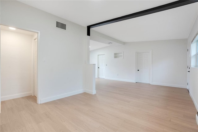 empty room with light hardwood / wood-style flooring and vaulted ceiling with beams