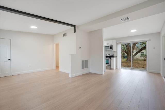 unfurnished living room with light hardwood / wood-style floors and beamed ceiling