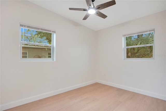 empty room with plenty of natural light, light hardwood / wood-style floors, and ceiling fan