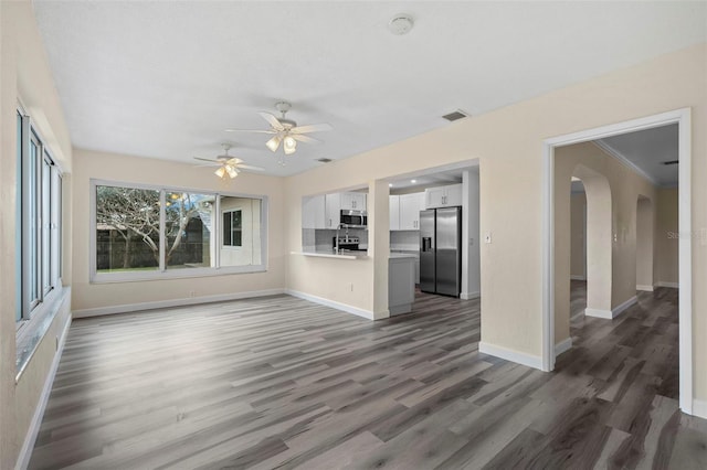 unfurnished living room with ceiling fan and dark hardwood / wood-style flooring