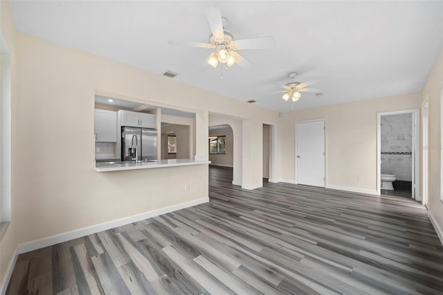 unfurnished living room with ceiling fan and dark hardwood / wood-style flooring