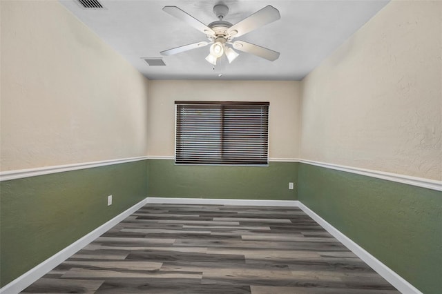 empty room with dark hardwood / wood-style floors and ceiling fan